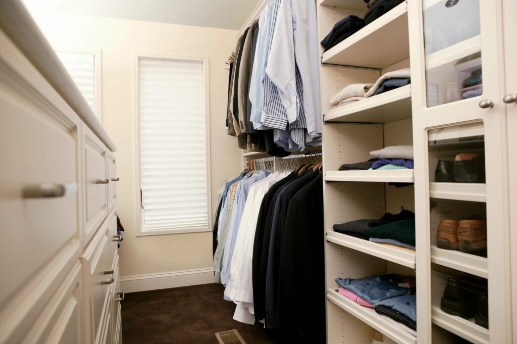 A closet with many clothes hanging on the rails.