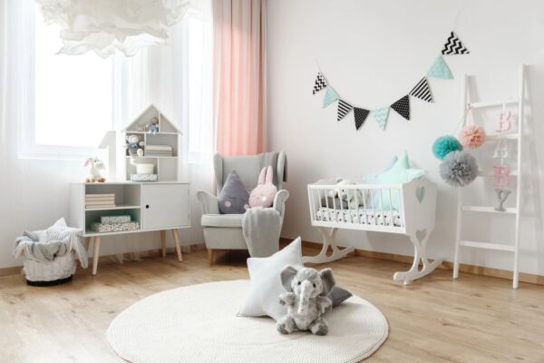 A room with a white rug and a baby 's crib.