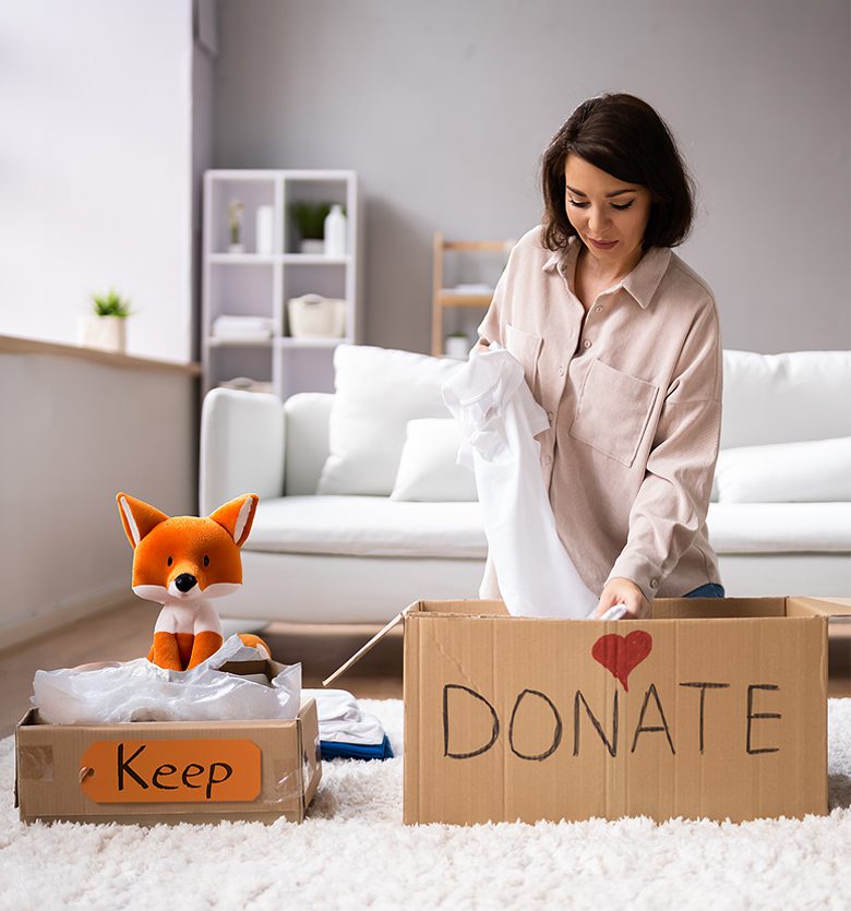 A woman is putting clothes in a box